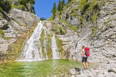 Deutschland, Bayern, Wanderin bewundert Glasbachwasserfall im Sommer - FOF13252