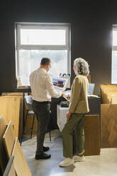 Zwei Kollegen betrachten den Ausdruck eines Hauses im Büro eines Architekten - SEAF01529