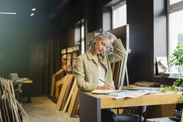 Architektin bei der Arbeit am Tisch im Büro - SEAF01568