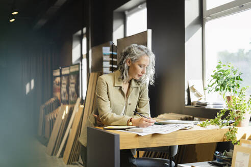 Architektin bei der Arbeit am Tisch im Büro - SEAF01569