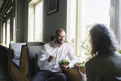 Businessman and businesswoman having lunch break in office together - SEAF01578