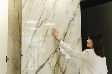 Woman touching marble plate in showroom - SEAF01632