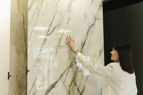 Frau berührt Marmorplatte im Ausstellungsraum - SEAF01632