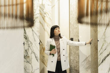 Frau berührt Marmorplatte im Ausstellungsraum - SEAF01633