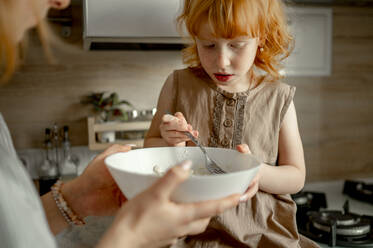 Daughter and mother preparing cheesecake at home - ANAF00713