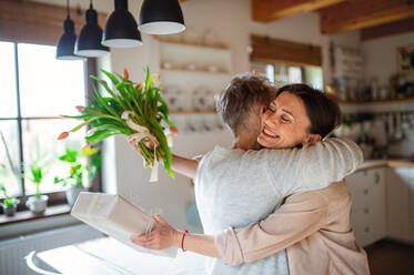 A happy senior mother hugging adult daughter indoors at home, mothers day or birthday celebration. - HPIF05165