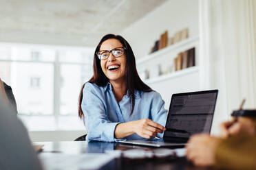 Business woman discussing a project report with her colleagues during a meeting. Creative business woman working in an advertising agency. - JLPSF28675