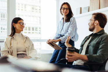 Team of professionals having a discussion in an office. Group of business people having a meeting in a modern workplace. - JLPSF28725