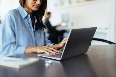 Webdesigner, der an einem Laptop in einem Büro arbeitet. Kreative Geschäftsfrau, die an einem Schreibtisch in einem Co-Working-Büro sitzt. - JLPSF28743