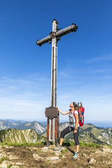 Deutschland, Bayern, Wanderin vor Gipfelkreuz auf der Rotwand stehend - FOF13266