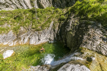 Deutschland, Bayern, Männlicher Wanderer kühlt sich in den Becken des Pfanngrabens ab - FOF13271