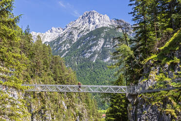 Österreich, Wanderin bewundert die Landschaft von der Brücke über die Leutaschklamm - FOF13306