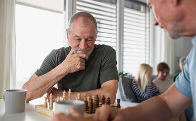 Gruppe glücklicher älterer Freunde, die drinnen Brettspiele spielen, Konzept für eine Party und ein geselliges Beisammensein. - HPIF05356