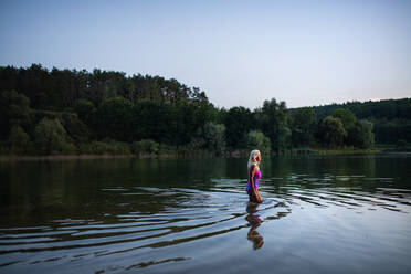 Eine Seitenansicht einer aktiven älteren Schwimmerin, die im Freien in einem See taucht. - HPIF05424