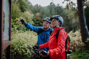 Eine glückliche ältere Paar Radfahrer Blick auf Karte im Freien in der Natur im Herbst Tag. - HPIF05455