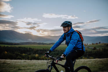 Ein aktiver älterer Mann Radfahren Fahrrad in der Natur im Herbst Tag. - HPIF05461