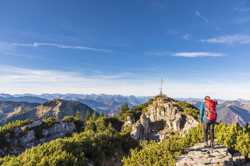 Germany, Bavaria, Female hiker admiring surrounding landscape from summit of Wallberg mountain - FOF13311