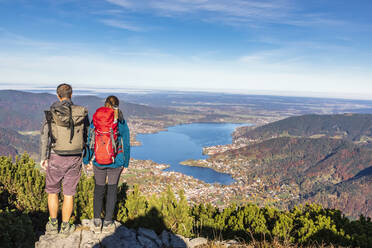 Deutschland, Bayern, Rottach-Egern, Wanderpärchen mit Blick auf den Tegernsee und die umliegenden Städte vom Gipfel des Wallbergs - FOF13314