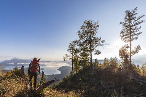 Deutschland, Bayern, Wanderin bewundert Blick auf den Walchensee, bei Sonnenaufgang - FOF13324