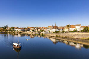 Frankreich, Nouvelle-Aquitaine, Bergerac, Boot auf dem Fluss Dordogne mit alten Gebäuden im Hintergrund - WDF07208