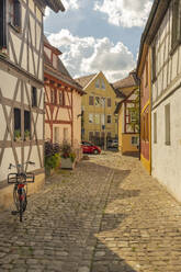 Germany, Bavaria, Forchheim, Half-timbered houses along cobblestone alley in Rosengasschen yawn - TAMF03808