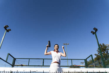 Aufgeregte Frau, die an einem sonnigen Tag auf dem Sportplatz jubelt - FMOF01621