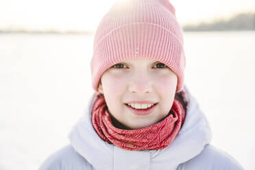 Glückliches Mädchen mit Strickmütze im Winter - EYAF02415