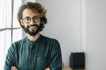 Glücklicher Freiberufler am Fenster eines Coworking-Büros - XLGF03158