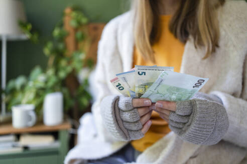 Hands of woman holding currency at home - SVKF00974