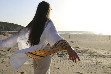 Woman with long hair walking at beach on sunny day, Patara, Turkiye - SYEF00196