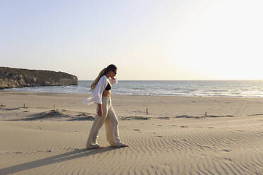 Young woman walking on sand at beach, Patara, Turkiye - SYEF00207