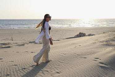 Young woman walking on sand dune at beach, Patara, Turkiye - SYEF00208