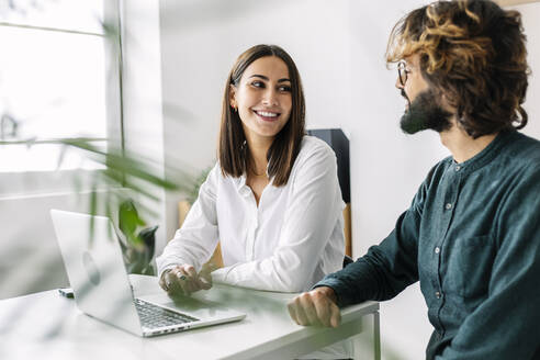 Happy business colleagues looking at each other in office - XLGF03208