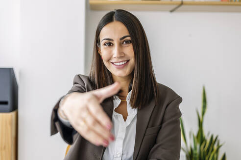 Lächelnder Personalverantwortlicher mit Handschlag-Geste im Büro - XLGF03219