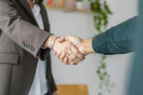 Recruiter shaking hand with candidate in office - XLGF03221