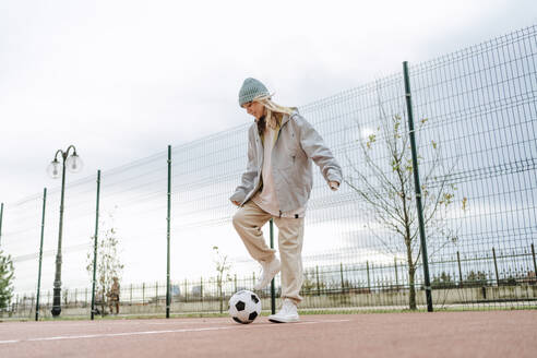 Teenager-Mädchen spielt mit Fußball - MDOF00457