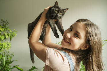 Happy girl playing with cat at home - OSF01259