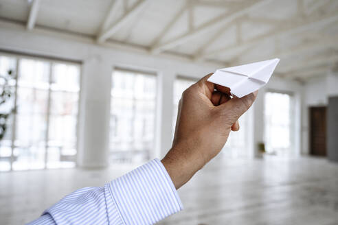 Hand of businessman holding paper airplane - EYAF02465