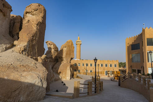 Saudi Arabia, Eastern Province, Al-Hofuf, Sandstone outcrops with mosque in background - RUNF04875