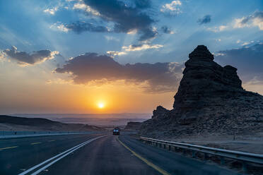 Saudi-Arabien, Al-Ula, Sonnenuntergang über abgelegener Landstraße - RUNF04881