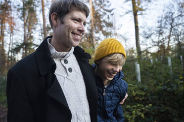 Glücklicher Vater und Sohn beim Spaziergang im Herbstwald - NJAF00103