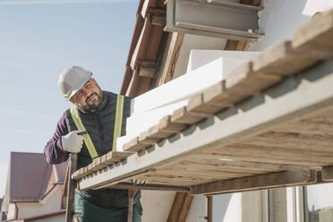 Bauarbeiter mit Polystyrolschaum auf der Baustelle - OSF01264