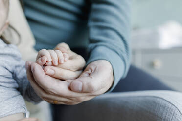 Vater und Mutter halten Händchen mit einem kleinen Jungen zu Hause - TYF00539