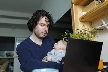 Freiberufler, der am Laptop arbeitet, während sein kleiner Sohn zu Hause schläft - TYF00546
