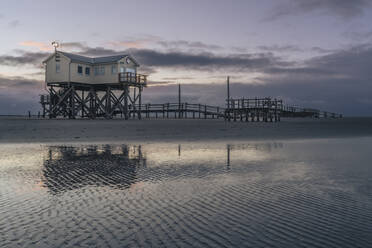 Germany, Schleswig-Holstein, St. Peter-Ording, Coastal stilt house at dawn - KEBF02546