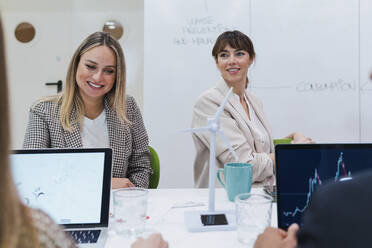 Smiling business colleagues having a meeting in office - PNAF04691