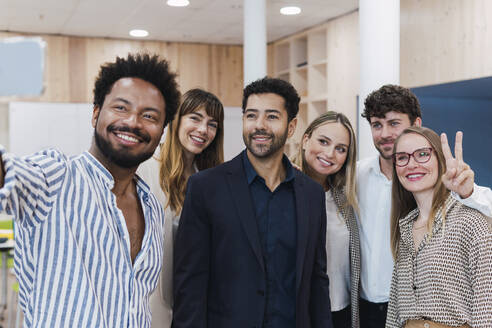 Happy business team posing for a selfie in office - PNAF04709