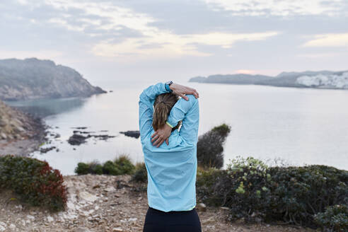 Frau beim Stretching vor dem Meer - JPTF01210