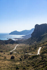 Oman, Dhofar, Salalah, Kurvenreiche Straße mit Küstenklippen im Hintergrund - RUNF04932