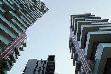 Low angle of futuristic glass skyscrapers located against dull sky on street of downtown in megalopolis in daytime - ADSF42230